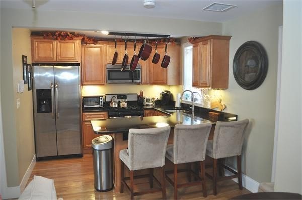 a dining room with furniture a large window and stainless steel appliances