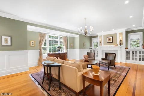 a living room with fireplace furniture and a chandelier