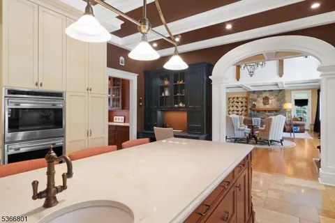 a room with stainless steel appliances kitchen island granite countertop furniture and a flat screen tv