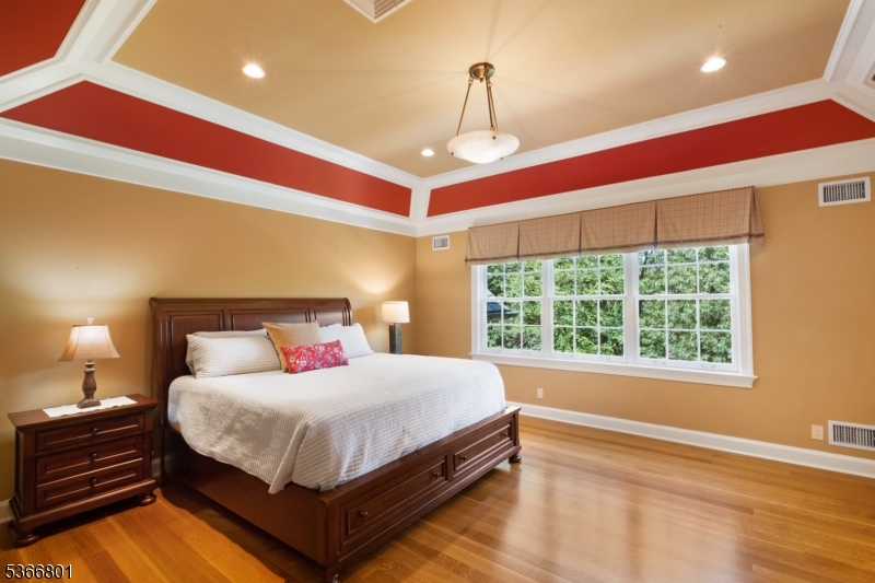 4 Rainetree Ridge Mendham Township, NJ 07945 - Photo 29 of 49 a bedroom with a bed and a chandelier