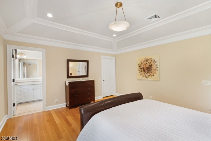 4 Rainetree Ridge Mendham Township, NJ 07945 - Photo 32 of 49 a bedroom with a bed and a chandelier