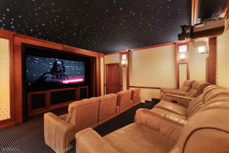 4 Rainetree Ridge Mendham Township, NJ 07945 - Photo 36 of 49 a living room with furniture a projector and a flat screen tv