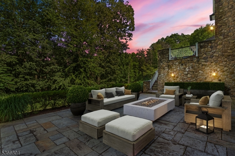 4 Rainetree Ridge Mendham Township, NJ 07945 - Photo 43 of 49 a view of a patio with couches and a table and chairs with wooden fence and plants