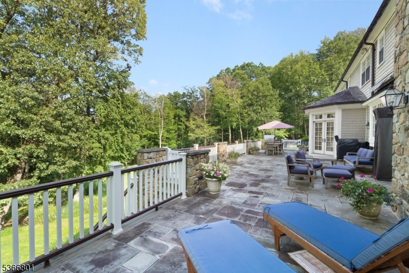 4 Rainetree Ridge Mendham Township, NJ 07945 - Photo 44 of 49 a view of a patio with couches table and chairs and potted plants with wooden floor and fence