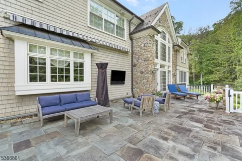 a view of a brick house with a chairs and table in a patio