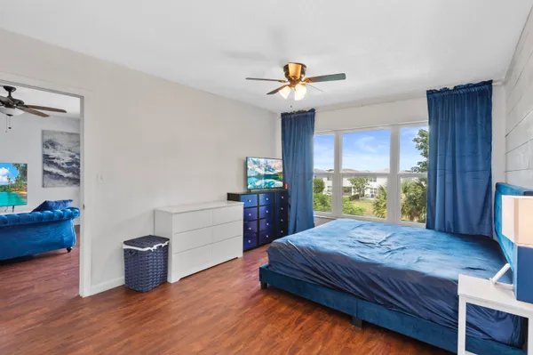 a view of a livingroom with wooden floor and a ceiling fan