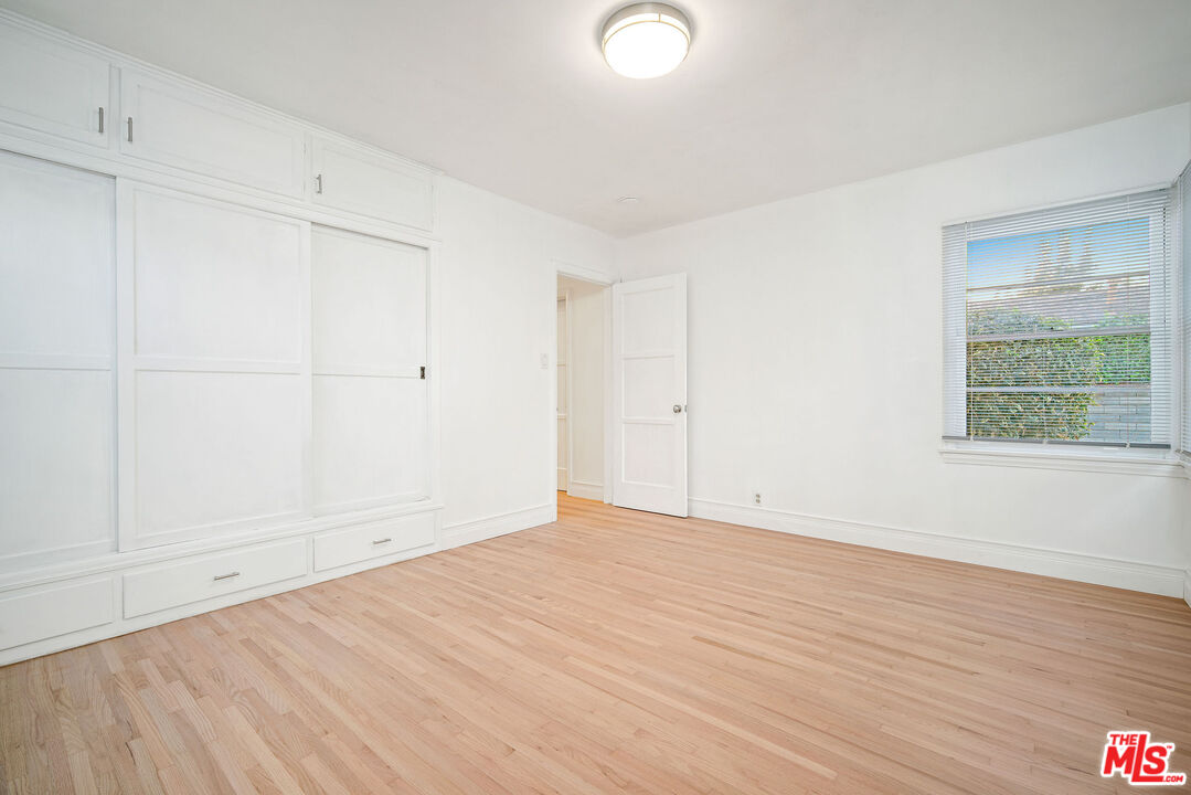1924 Armacost Avenue Los Angeles, CA 90025 - Photo 23 of 33 a view of an empty room with wooden floor and a window