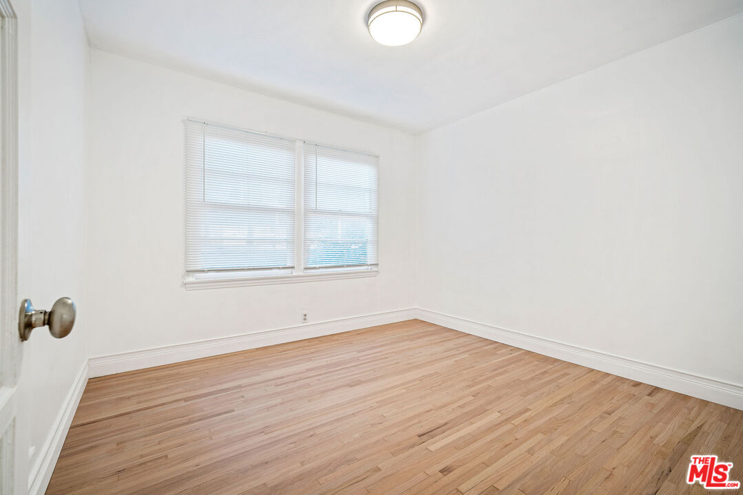 1924 Armacost Avenue Los Angeles, CA 90025 - Photo 24 of 33 an empty room with wooden floor and windows