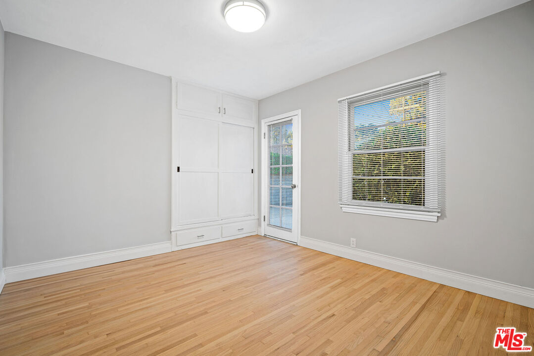 1924 Armacost Avenue Los Angeles, CA 90025 - Photo 28 of 33 a view of an empty room with wooden floor and a window