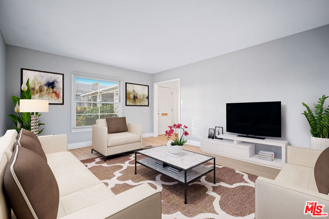 1924 Armacost Avenue Los Angeles, CA 90025 - Photo 6 of 33 a living room with furniture a rug and a flat screen tv