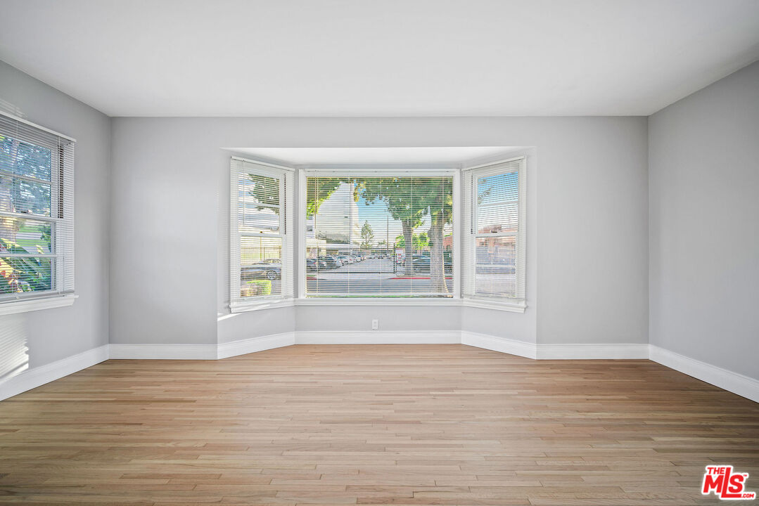 1924 Armacost Avenue Los Angeles, CA 90025 - Photo 8 of 33 a view of an empty room with wooden floor and a window