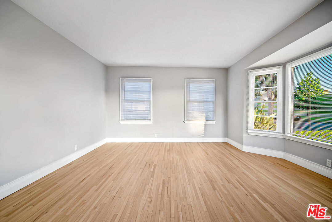 1924 Armacost Avenue Los Angeles, CA 90025 - Photo 9 of 33 an empty room with wooden floor and windows