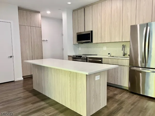 a kitchen with stainless steel appliances a refrigerator sink and microwave