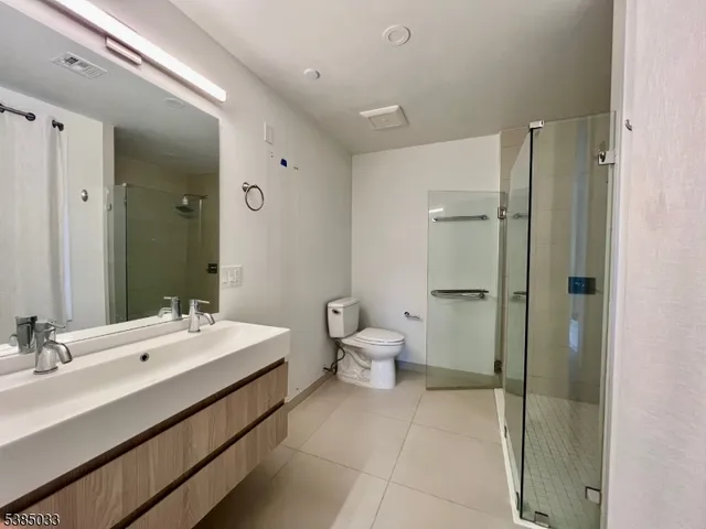 a bathroom with a double vanity sink mirror and toilet