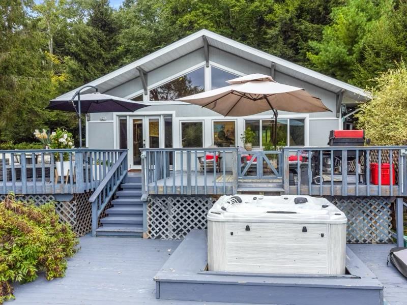 42 Lake Muskoday Road Roscoe, NY 12776 - Photo 1 of 1 Rear view of house featuring a wooden deck and a hot tub
