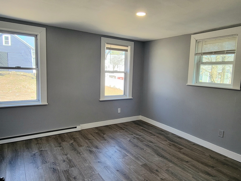 136 Commonwealth Road Wayland, MA 01778 - Photo 9 of 27 a view of an empty room with wooden floor and a window