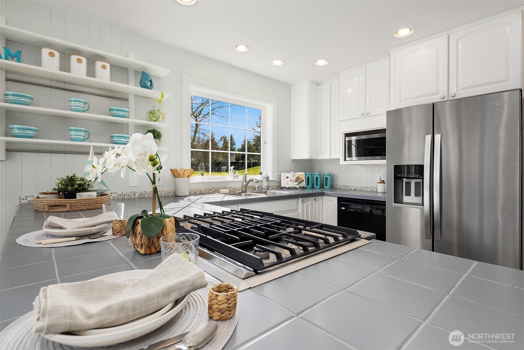 1316 East Backswing Lane Freeland, WA 98249 - Photo 19 of 37 a kitchen with stainless steel appliances a stove a refrigerator a sink a counter top space and living room view