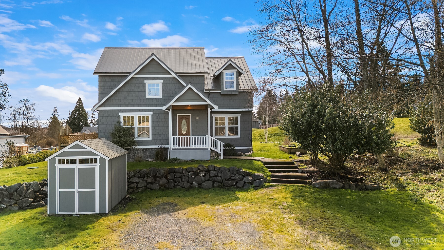 1316 East Backswing Lane Freeland, WA 98249 - Photo 2 of 37 a front view of a house with a yard garage and outdoor seating