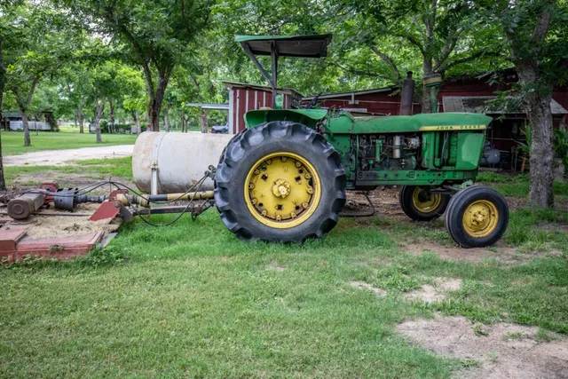 a backyard of a house with wooden fence and a table and chairs