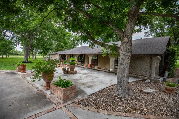 a front view of a house with garden and patio