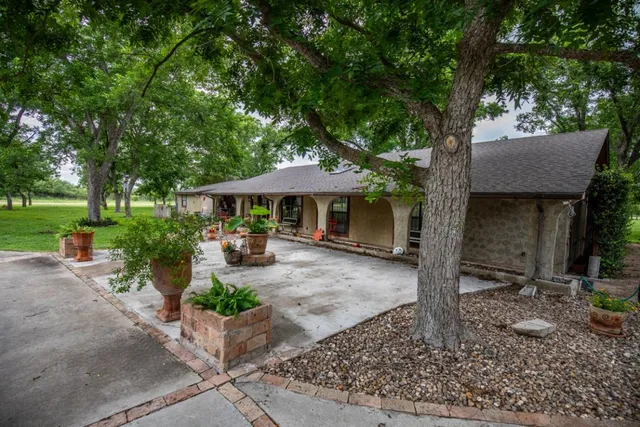 a front view of a house with garden and patio
