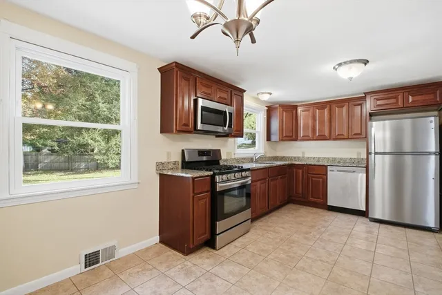 a kitchen with stainless steel appliances granite countertop a refrigerator stove top oven and sink