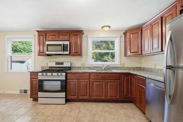 a kitchen with stainless steel appliances granite countertop a stove sink and microwave