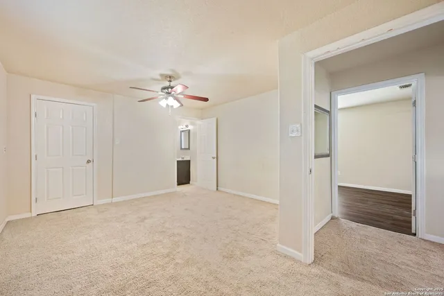 a view of an empty room with a ceiling fan