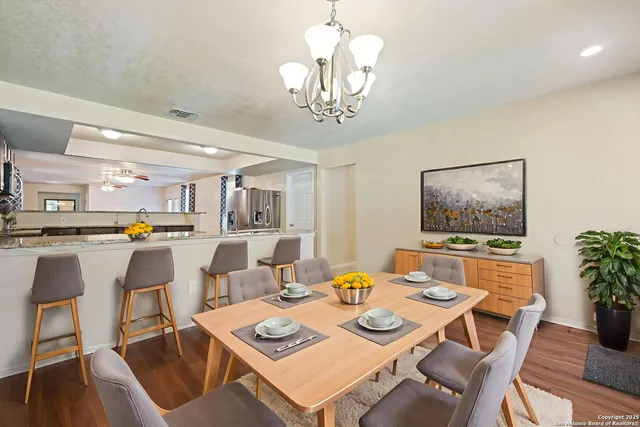 a dining room with furniture a rug and a chandelier