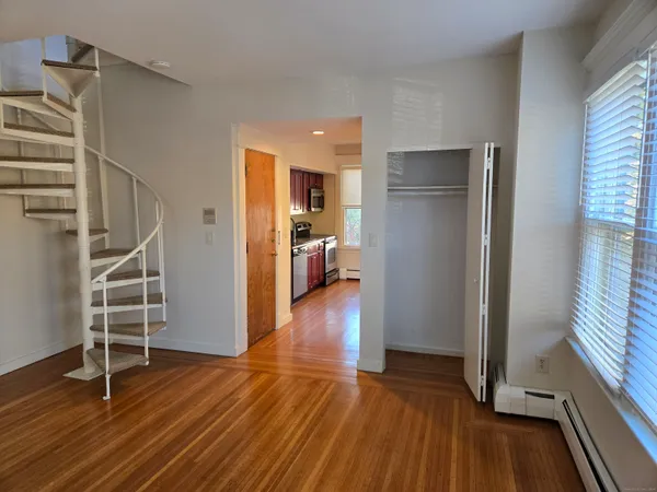 a view of empty room with wooden floor and stairs