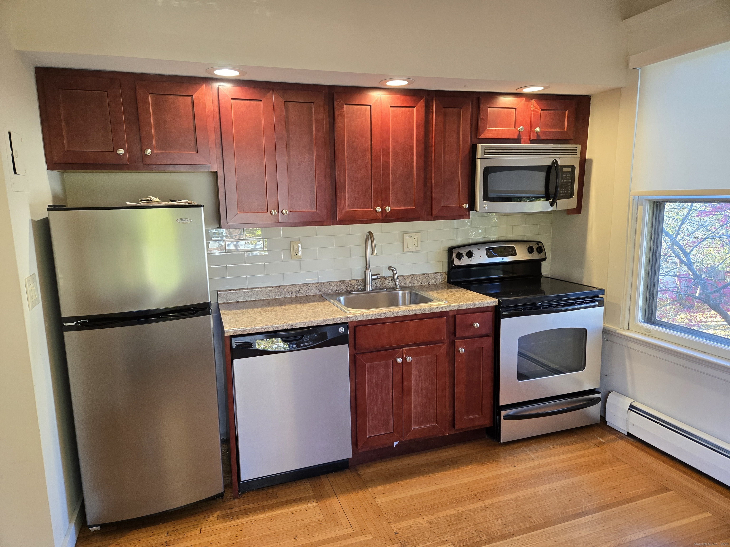 188 Cold Spring Street, Unit 3 New Haven, CT 06511 - Photo 6 of 20 a kitchen with stainless steel appliances granite countertop a refrigerator stove a sink and dishwasher with wooden floor