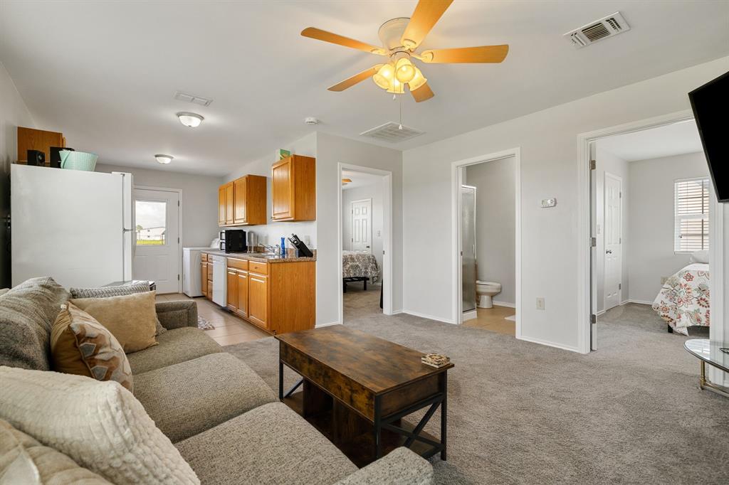 12240 Wellington Road Ponder, TX 76259 - Photo 35 of 40 Open-concept living area featuring light gray walls, carpet flooring, and a ceiling fan with integrated lighting