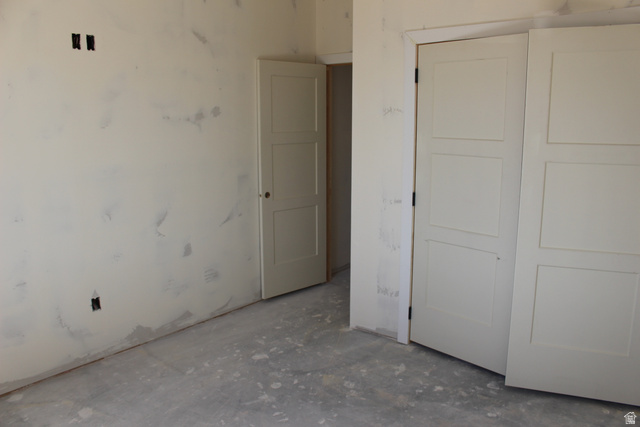 4933 East Remington Road Cedar City, UT 84721 - Photo 13 of 33 Interior room showcasing a paneled door, a paneled bi-fold door, and unfinished walls