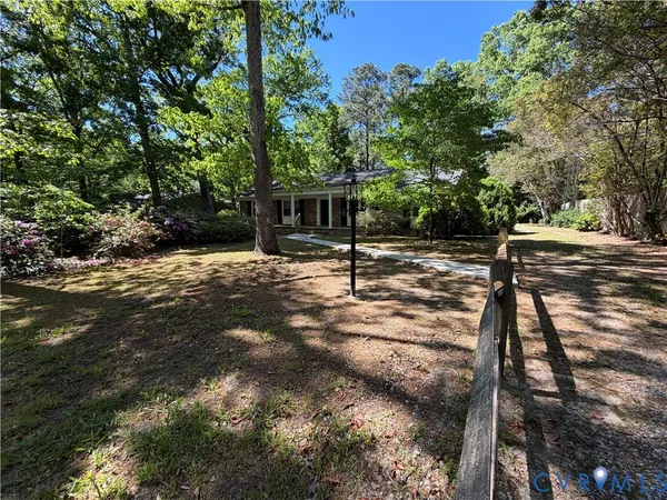 a backyard of a house with table and chairs and wooden fence