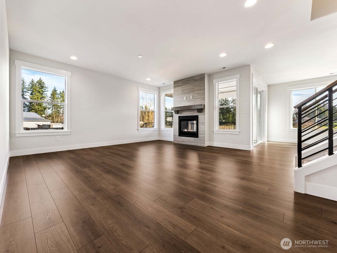25012 181st Avenue Southeast, Unit 5 Covington, WA 98042 - Photo 5 of 34 an empty room with wooden floor fireplace and windows