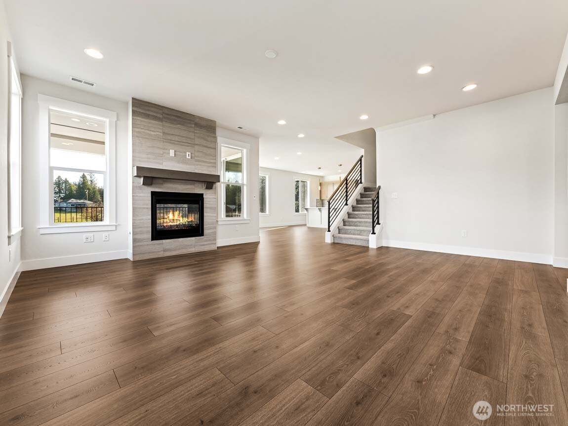 25012 181st Avenue Southeast, Unit 5 Covington, WA 98042 - Photo 6 of 34 a view of an empty room with wooden floor fireplace and a window