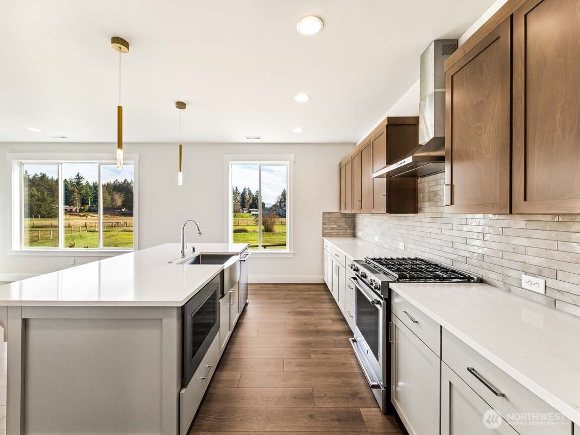 25012 181st Avenue Southeast, Unit 5 Covington, WA 98042 - Photo 9 of 34 a kitchen with stainless steel appliances a sink stove and cabinets