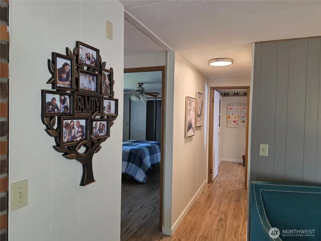 a view of a hallway with wooden floor and closet