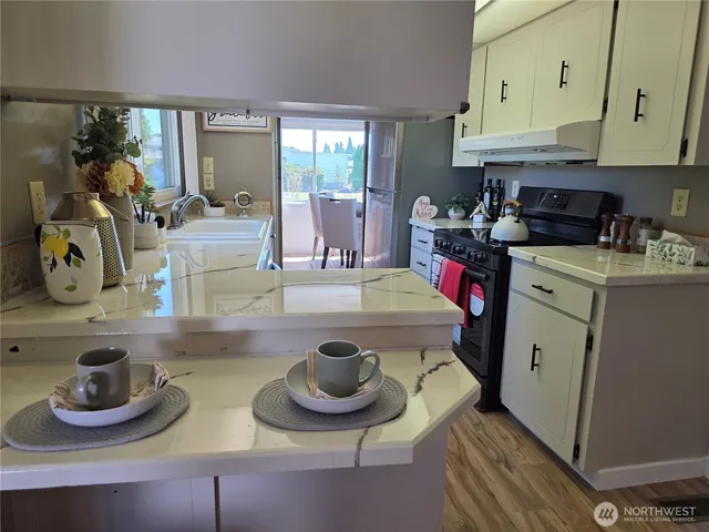 a kitchen with a stove and a wooden floor