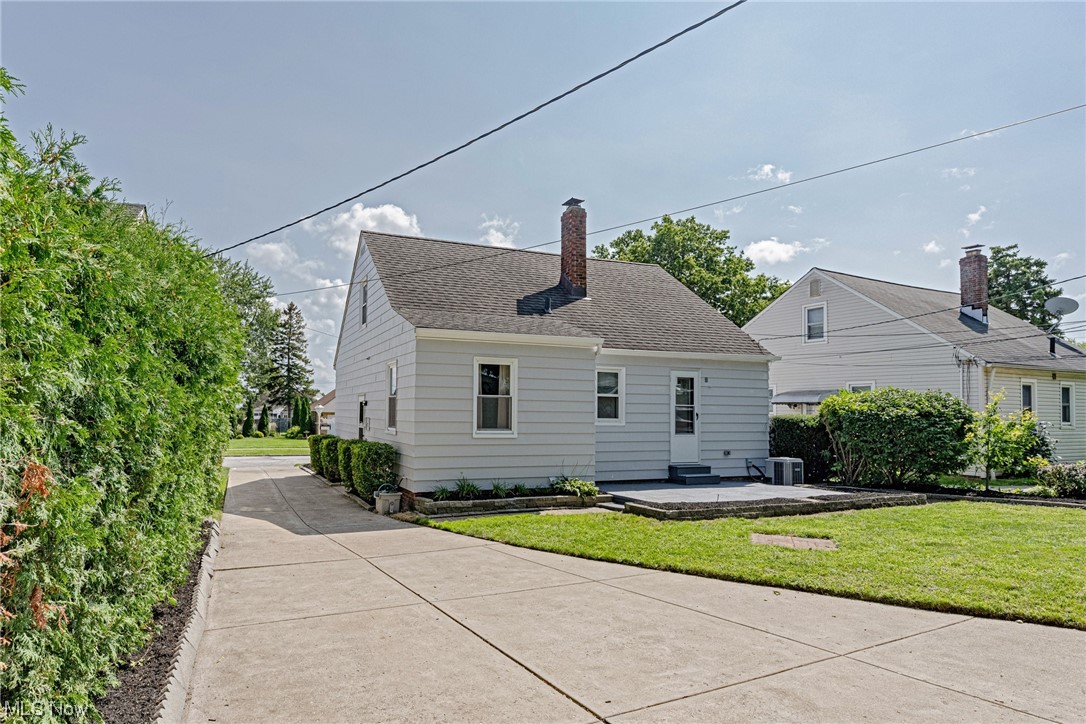 11815 Derby Road Garfield Heights, OH 44125 - Photo 29 of 31 Rear view of house with a lawn, a patio area, and central AC unit