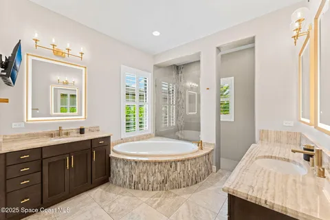 a spacious bathroom with a tub sink and mirror