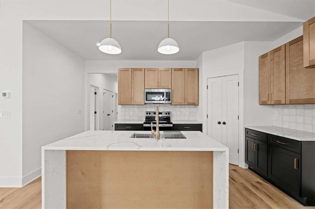 409 Lively Road Waco, GA 30182 - Photo 11 of 50 a kitchen with stainless steel appliances granite countertop a sink a stove and a refrigerator