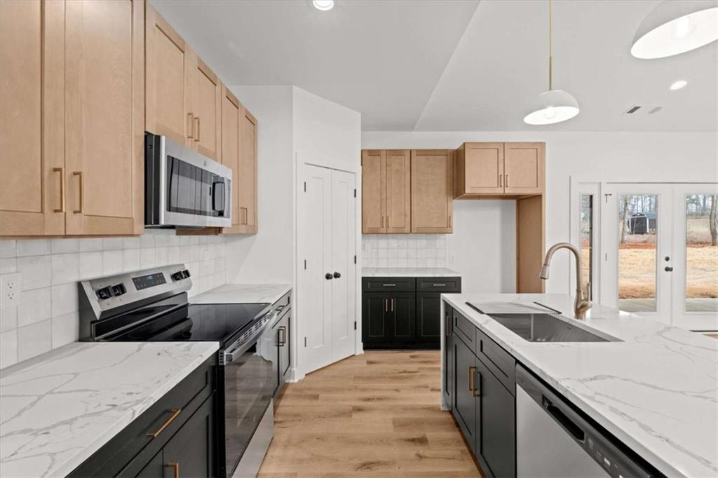 409 Lively Road Waco, GA 30182 - Photo 13 of 50 a kitchen with stainless steel appliances granite countertop a sink stove and refrigerator
