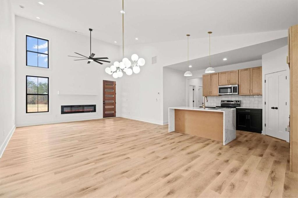 409 Lively Road Waco, GA 30182 - Photo 10 of 50 a large kitchen with kitchen island a sink dishwasher a refrigerator and a wooden floor