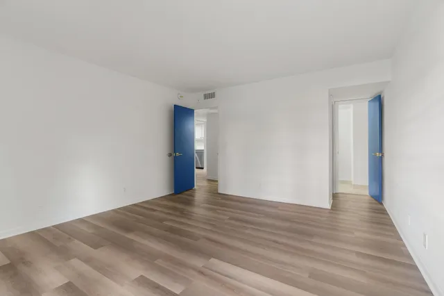 a view of an empty room with wooden floor