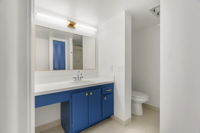 a bathroom with a toilet a sink and mirror
