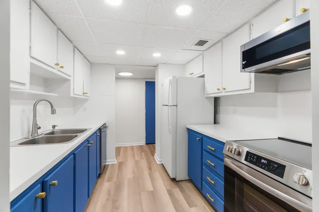 a kitchen with stainless steel appliances granite countertop a sink a stove and a refrigerator