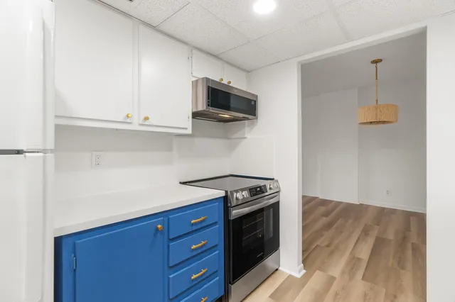 a kitchen with stainless steel appliances granite countertop a stove a microwave and a refrigerator