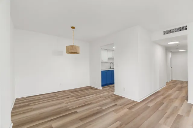 a view of a room with wooden floor and ceiling fan