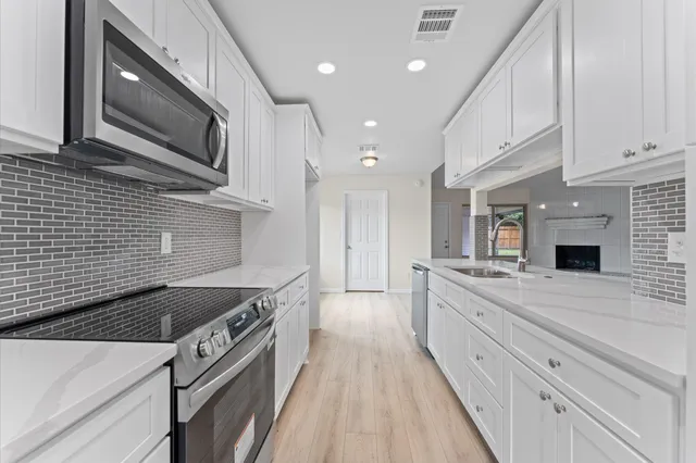 a kitchen with stainless steel appliances granite countertop a sink and a stove
